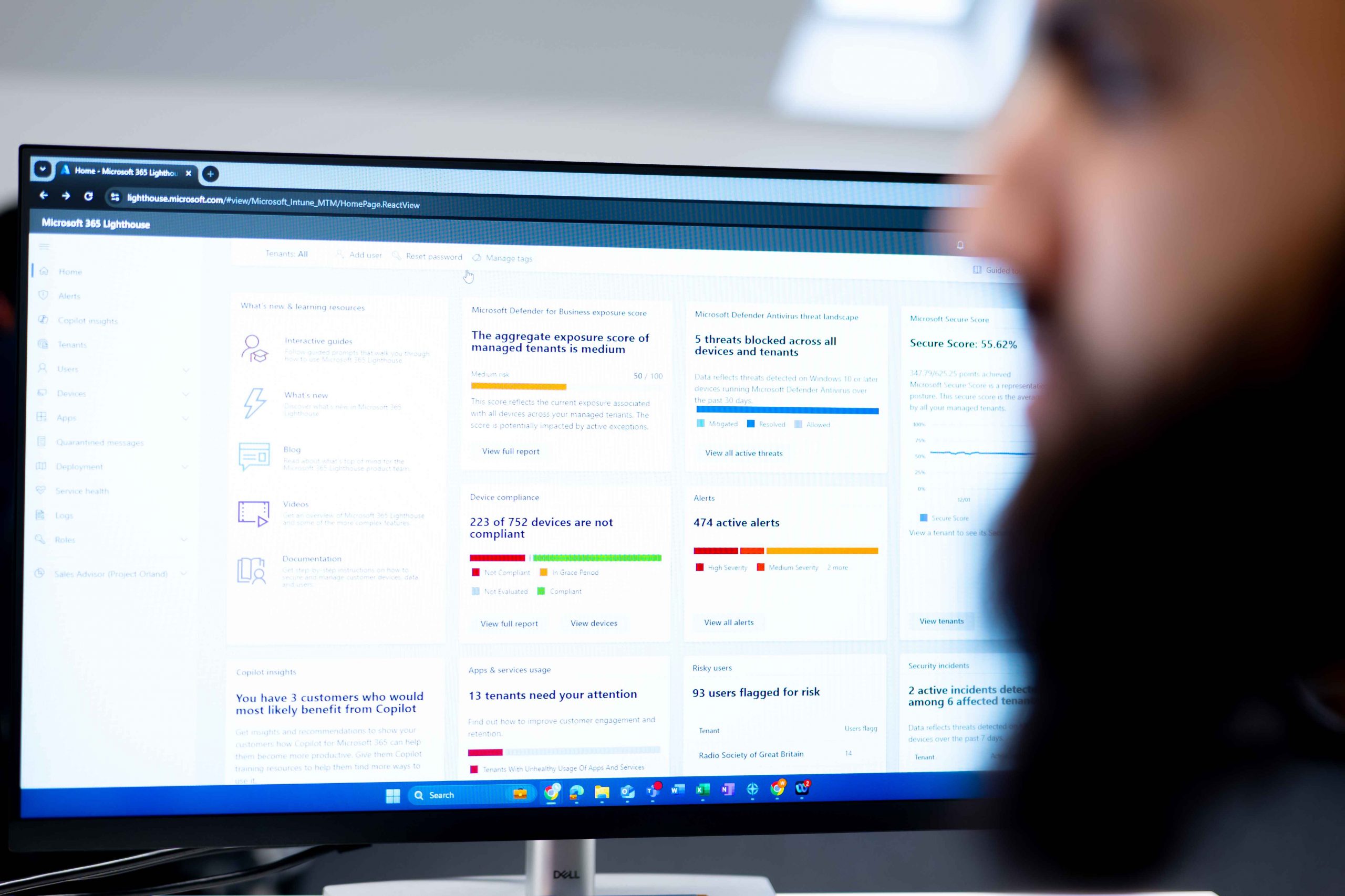 Engineer reviewing Microsoft 365 Lighthouse dashboard for security and compliance insights at Bluebell IT Solutions.